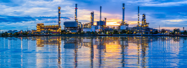 Wide coastal view of illuminated petroleum infrastructure across the water