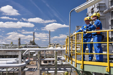 Aoshan terminal operators inspecting pipeline equipment from an elevated platform