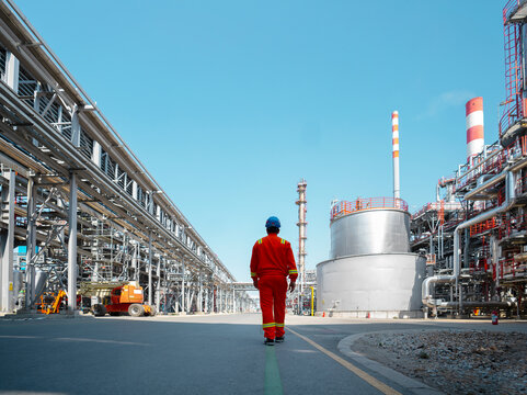 Terminal operator walking through petroleum processing infrastructure